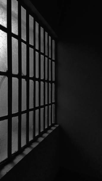 istock The windowpane reflects the ambient light, casting a subtle glow amidst the darkness, evoking a sense of mystery and solitude. 2006341011