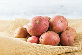 Red potatoes close-up. Fresh raw organic red potatoes close-up on a rustic background