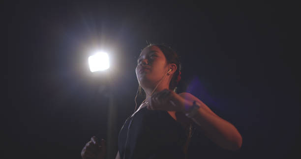 istock Young woman athlete stretching and warming up before training at night. 2006543158