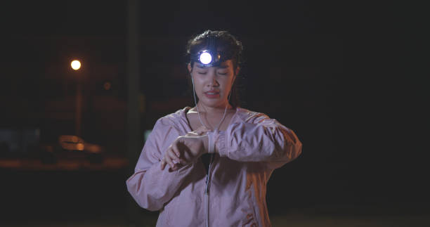 istock Young woman athlete use smart watch checking heart rate and use a flashlight on head while exercise at night 2006546799