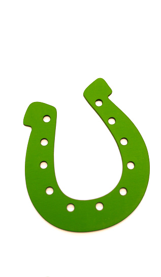 Golden horseshoe with phrase GOOD LUCK and clover on white background. St. Patrick's Day celebration