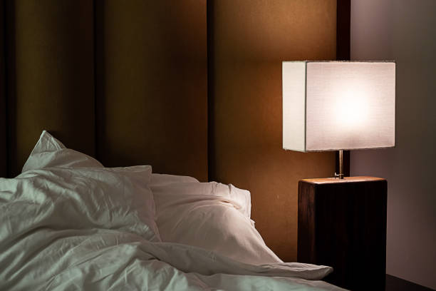 istock Trendy bedroom interior with luminous lamp with lampshade. 2006567573