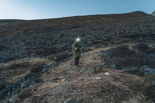 Mountaineers Wearing Headlamps on the Highland Meadow at Sunset