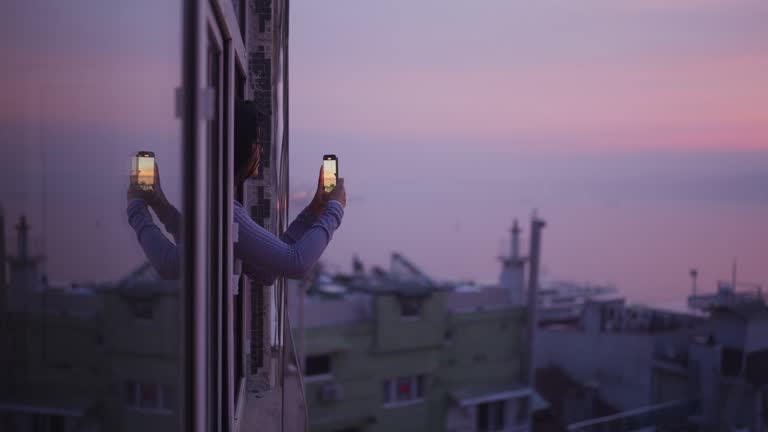 Multiracial female tourist taking photos and videos wtih her mobile smart phone in Istanbul during her travel