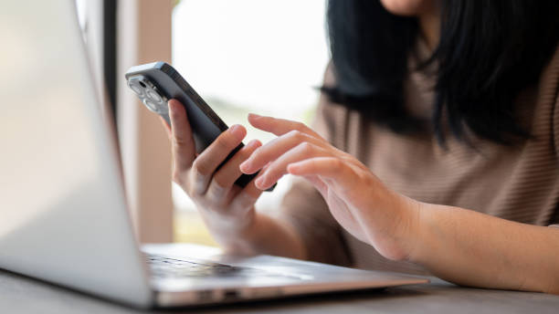 istock A woman using her smartphone, responding to messages while sitting in a cafe co-working space. 2006638759