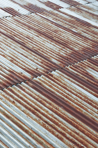 abstract of old metal sheet roofing, rusty galvanized corrugated roofing widely used for its durability and distinctive appearance, soft focus with copy space