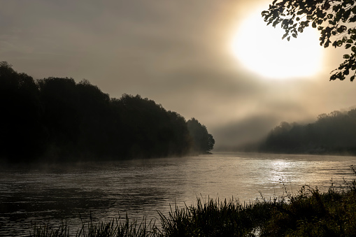 Foggy morning on the river, sunrise dispels a little fog in the lowlands