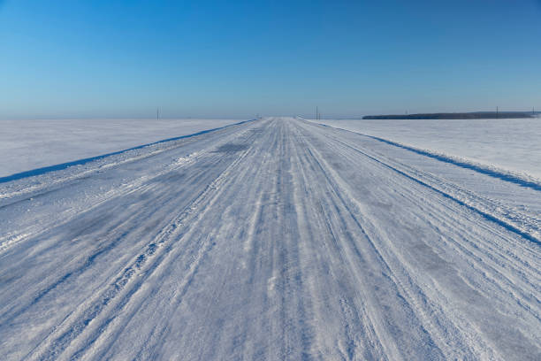 a snow- covered road in winter , a slippery and dangerous road covered with snow and ice