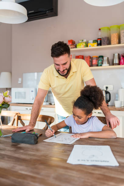 istock Caucasian Father Helping Mixed Race Daughter with Homework at Home 2006776644