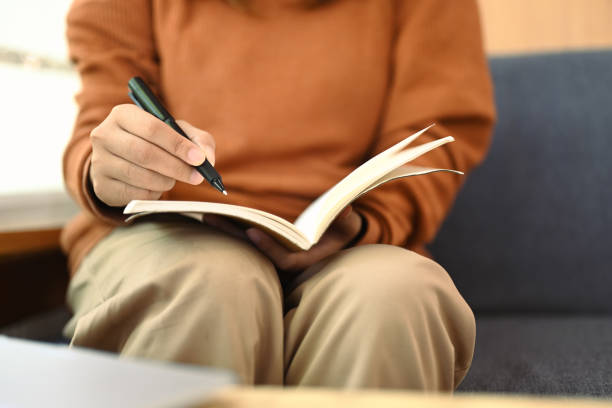 istock Unrecognizable young woman writing notes in personal daily planner or planning workday 2006808480