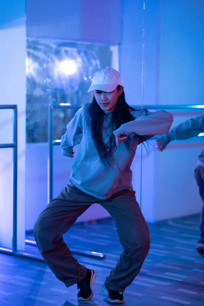 istock Young Asian woman practicing modern dance styles in a studio with neon light 2006809528