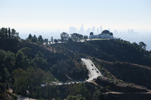 Griffith Observatory and Los Angeles skyline. Road leading to the Observatory and trails through the trees.