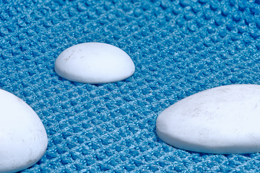 Conceptual composition of rounded stones over a blue textured cloth