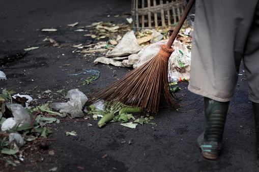 Man using broom sweeping street or floor city garbage cleaning service concept. Maintenance worker cleaning the road with a broom. Copy space