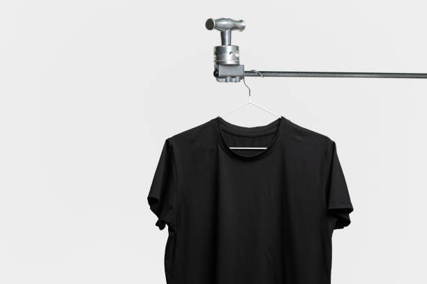 istock Plain black T-shirt hanging on hanger on gray background 2006930170
