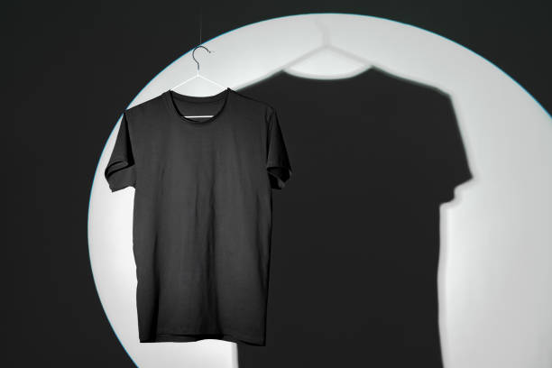 istock Plain black T-shirt hanging on hanger on gray background 2006945225