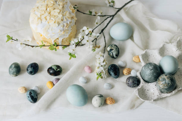istock Stylish easter eggs, panettone and spring flowers on linen cloth on rustic table. Natural dye eggs and cherry blossom, festive minimal flat lay. Happy Easter! 2006981509