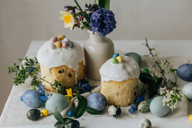 istock Happy Easter! Stylish easter eggs, homemade easter bread and spring flowers on linen napkin on rustic table. Natural painted marble eggs, blooms and holiday food. Modern still life 2006983145
