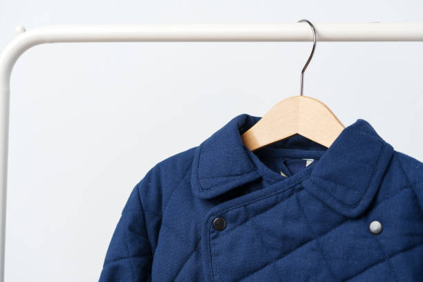 istock Blue quilted kids coat on hanger against white wall 2006988303