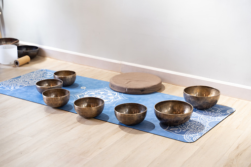 A picture capturing the presence of a singing bowl, often utilized for healing, situated on a wooden surface