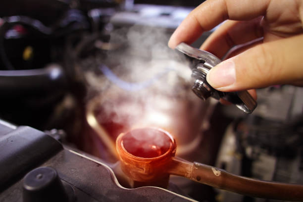 istock Auto mechanic hand opens the radiator cap with steam escaping around the engine compartment from the high heat 2007019921