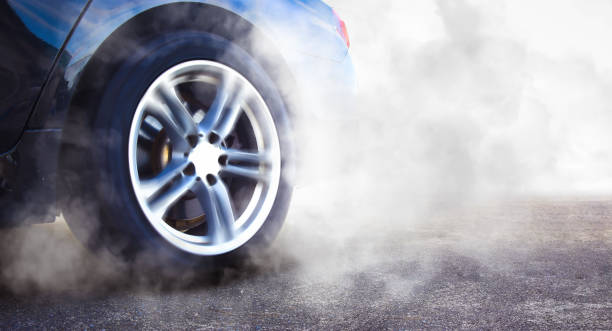 The wheels of the race car spin at speed on track and are covered with smoke, racing car drifting and burning tire , copy space The wheels of the race car spin at speed on track and are covered with smoke, racing car drifting and burning tire , copy space , Car competition concept car burnout stock pictures, royalty-free photos & images