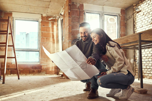 istock Happy couple analyzing plans at their renovating apartment. 2007020979