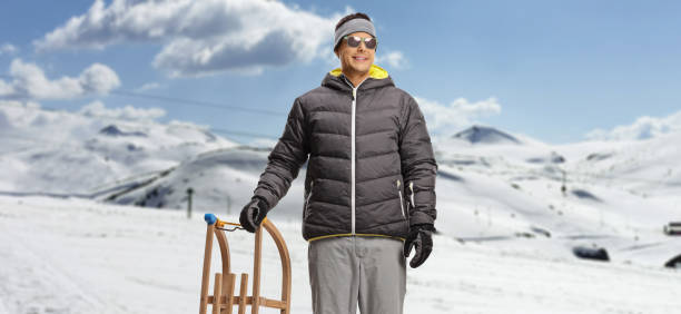 istock Man on a mountain standing with a wooden sleigh 2007049384