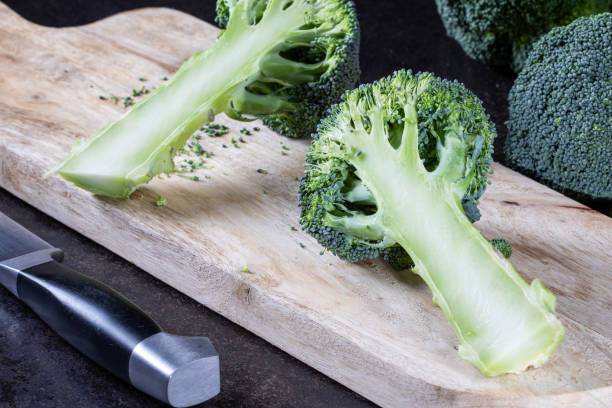 istock Fresh green broccoli florets on a wooden cutting board with a knife 2007085572