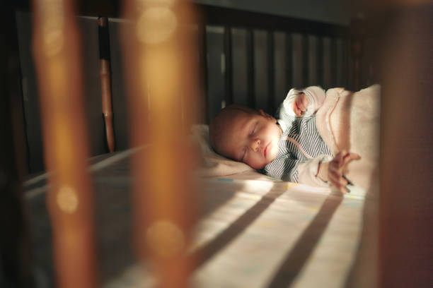Close-up of a newborn baby girl peacefully sleeping in the crib.