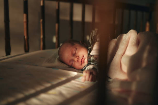 Close-up of a newborn baby girl peacefully sleeping in the crib.
