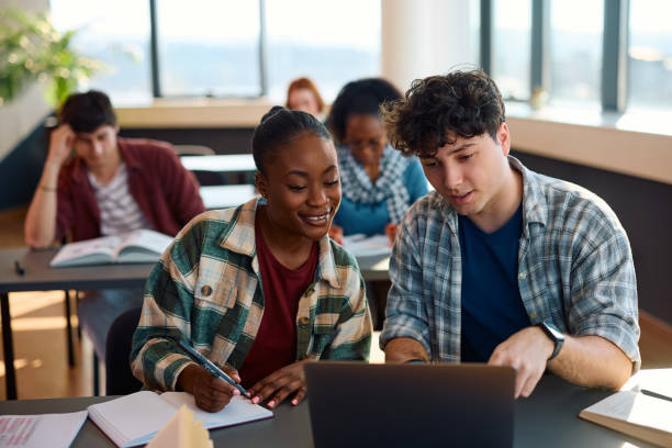 istock Happy multiracial students e-learning on laptop while studying in the classroom at university. 2007098336