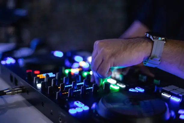 Photo of Close up of a DJ's hands on the remote