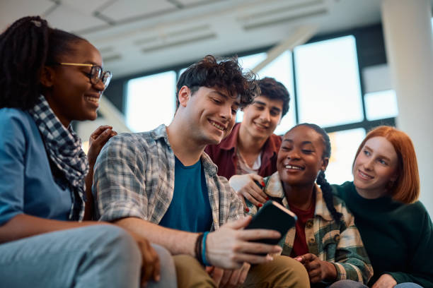 istock Multiracial group of happy students using cell phone in lecture hall. 2007103597