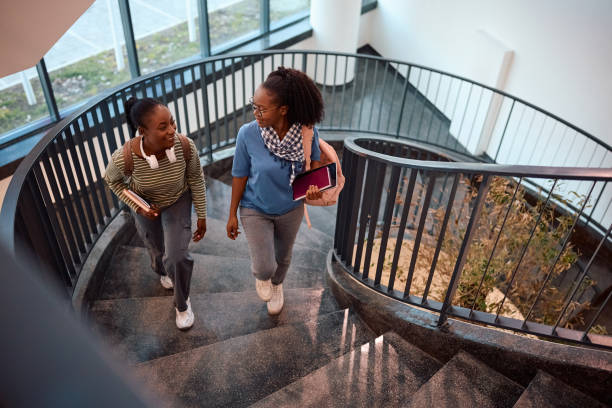 istock Black female friends communicating while going to a lecture at college. 2007104667