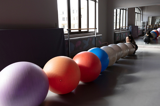 Ballerina posing with swiss balls before doing her daily routine.