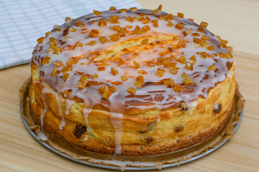 Homemade round cheesecake with icing and candied orange peel