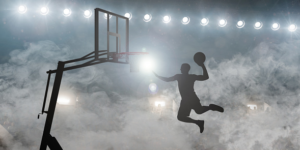 A dynamic silhouette of a basketball player soaring for a slam dunk in a smoke-enshrouded stadium under bright lights