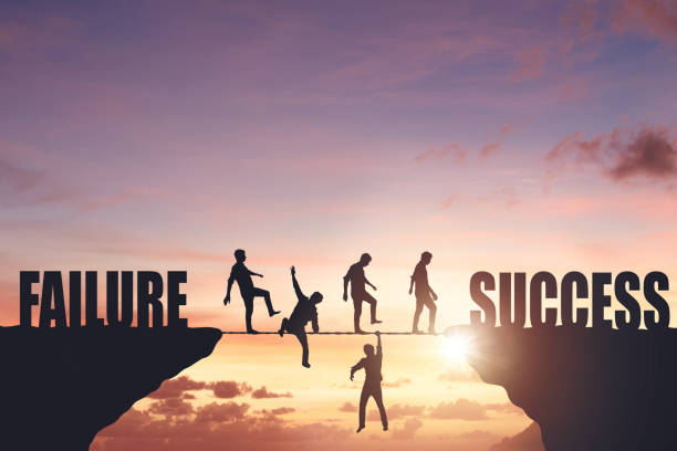 istock Silhouettes of people walking on a rope between rocks, success concept 2007275875