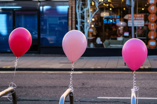 West 14th Street, Manhattan, New York, USA, December 13, 2019:  Man moving helium filled balloons in the street