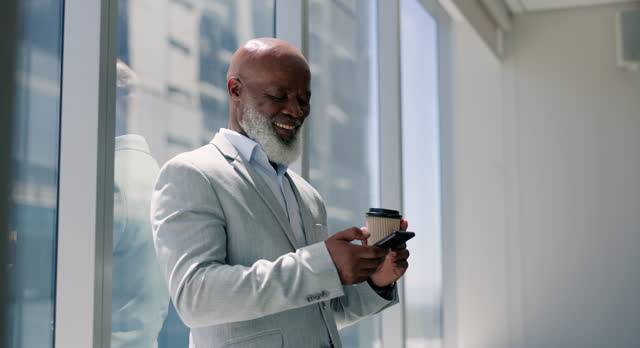 Reading, phone and businessman in office on coffee break with social media and online networking. Mature, black man and relax with smartphone in morning to scroll virtual chat and communication