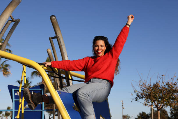 Happy little boy whit outstretched hands having fun during sunny day on playground