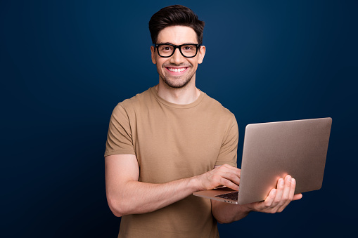 Photo of nice attractive man wear stylish beige clothes promote modern device gadget macbook isolated on dark blue color background