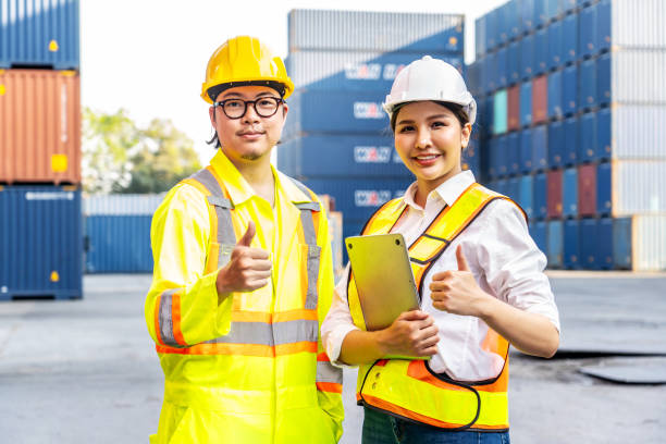 istock Two Southeast Asian engineers posing confidently in front of shipping containers. 2007373179
