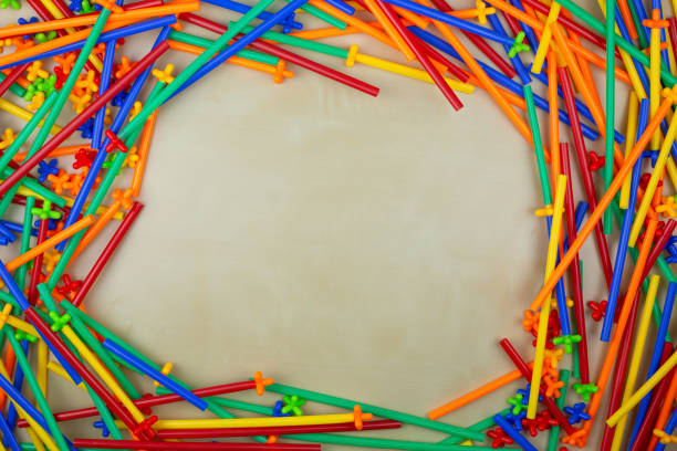 Multi colored parts of flexible tubular construction set form frame with empty space on the table, place for text with a decorated details of children constructor parts for play