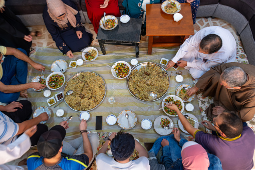 arabic family having lunch together, feeling excited and cheerful expressions on their faces, family moments during ramadan