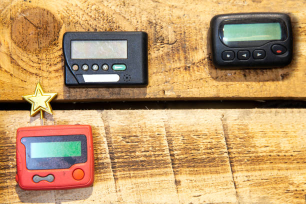 istock Three different vintage pagers on a wooden background. Place for text 2007427004