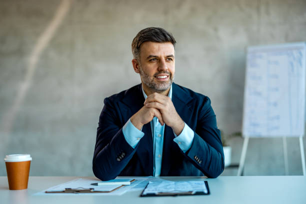 professionnel masculin qui réfléchit aux possibilités de carrière dans les entreprises. - small business enjoyment growth planning photos et images de collection