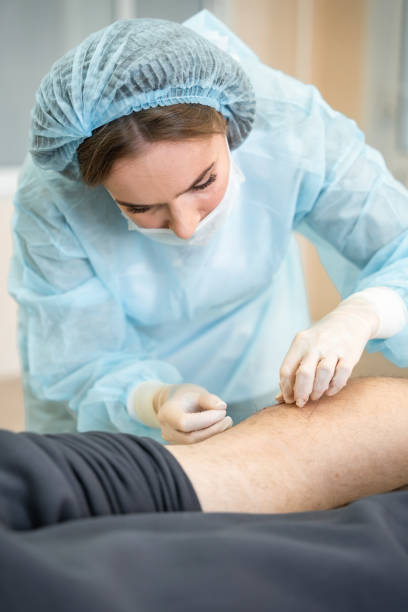 istock Portrait of dermatologist surgeon stitching up a wound after surgery, operation process 2007449461