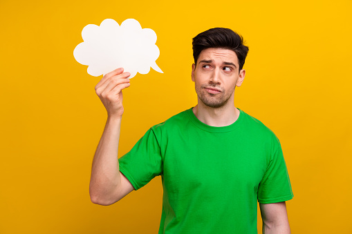 Portrait of guy deep thinking hold paper bubble cloud deciding new creative idea for fintech startup isolated on yellow color background.